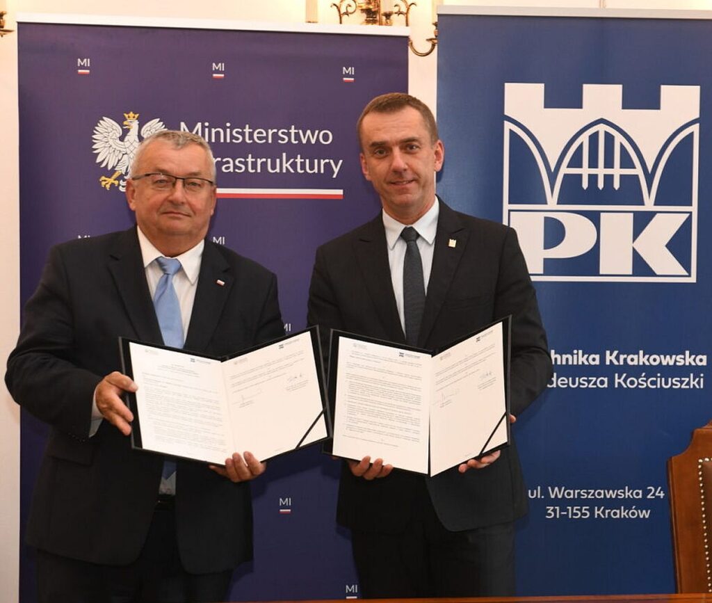 Zdjęcie ministra infrastruktury Andrzeja Adamczyka i rektora Politechniki Krakowskiej prof. Andrzeja Szarata trzymających listy intencyjne